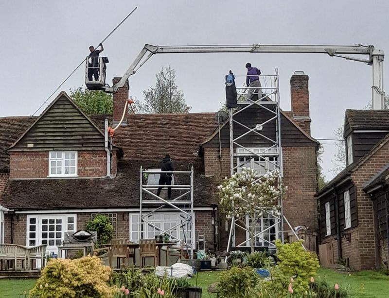 The Moss Cleaners using cherry picker and scaffolding to clean roof safely and professionally in Norbiton, London